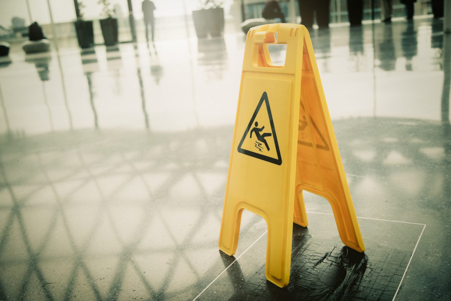 Yellow warning sign on shiny floor