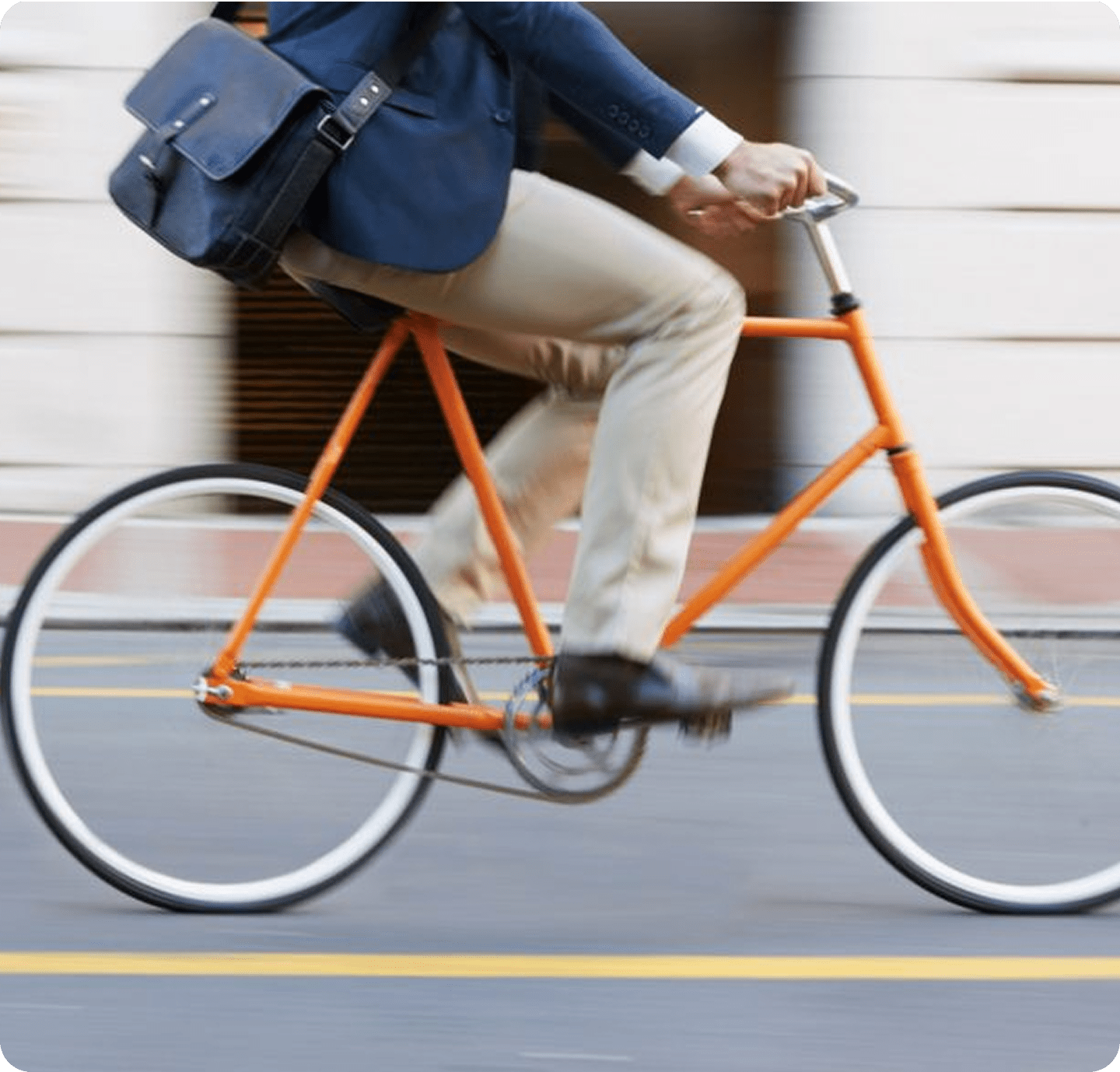 Man rides orange bicycle in city