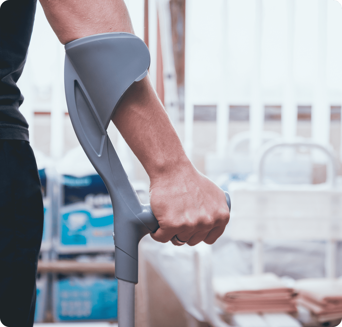 Arm holding grey crutch indoors