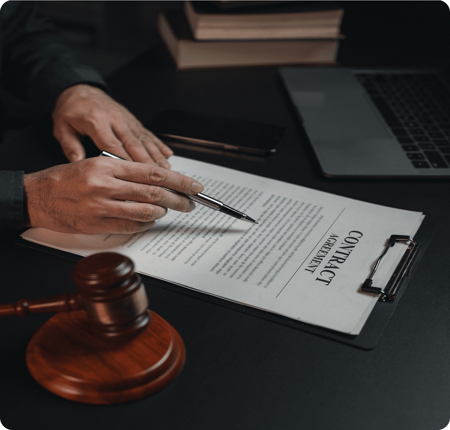 Person reviewing contract near laptop