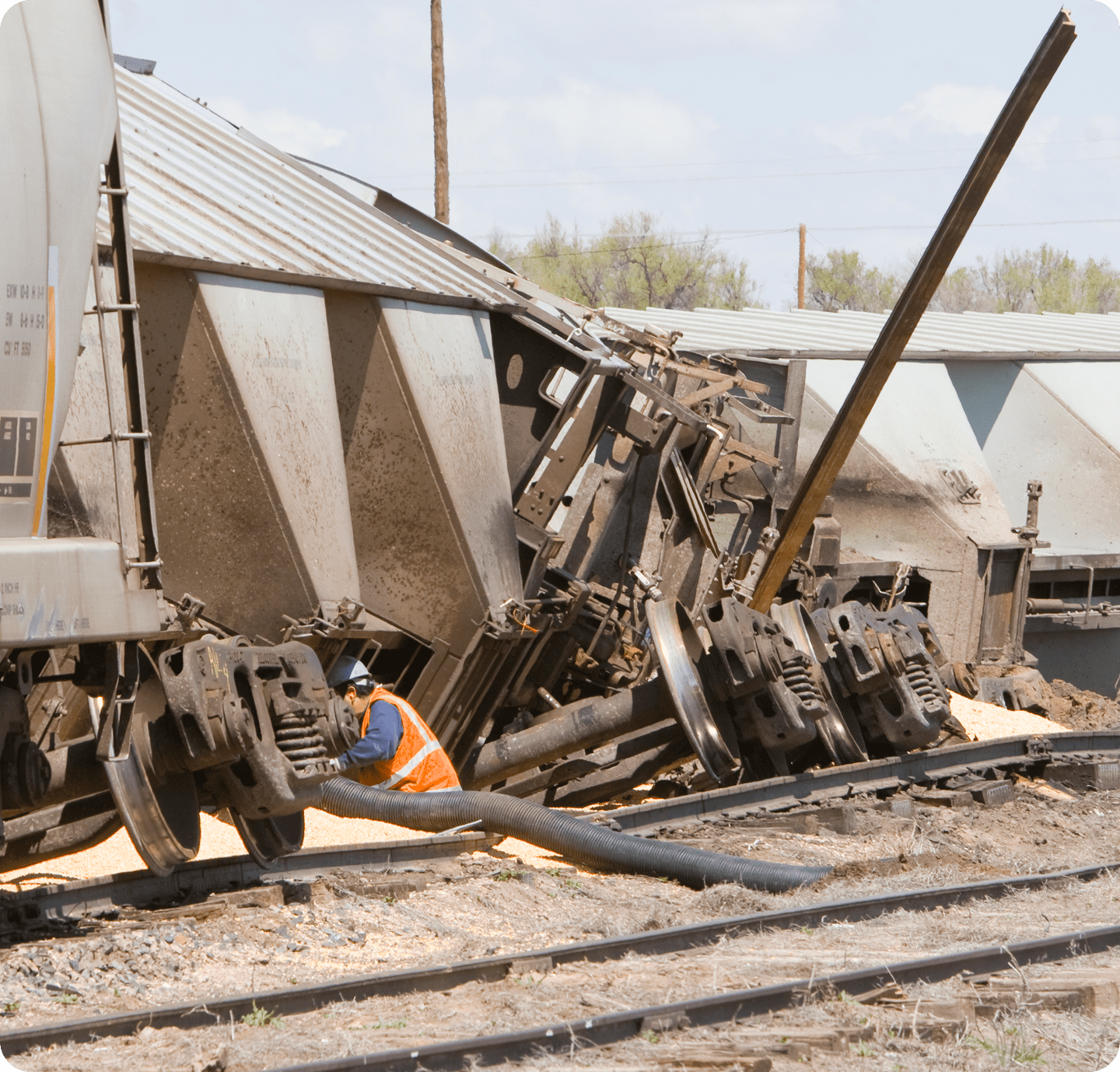 Worker inspecting derailed train carriages