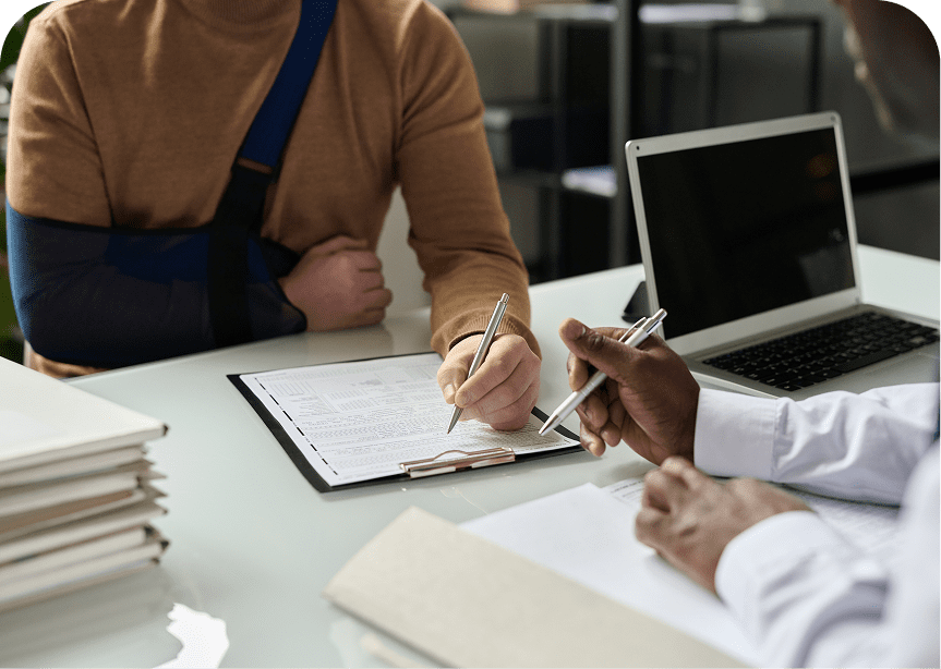 Person with arm sling signing documents