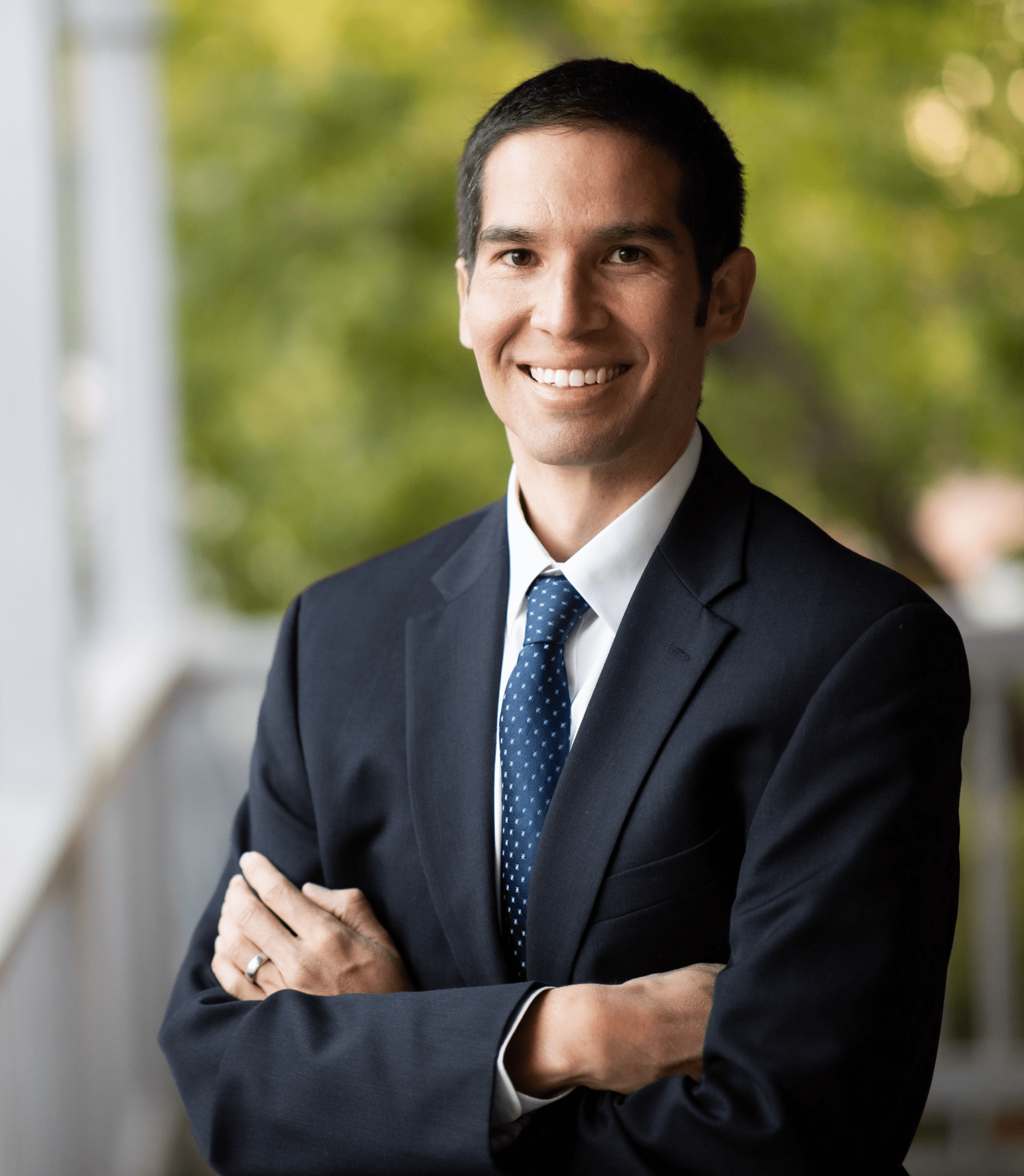 Smiling man in suit and tie, arms crossed