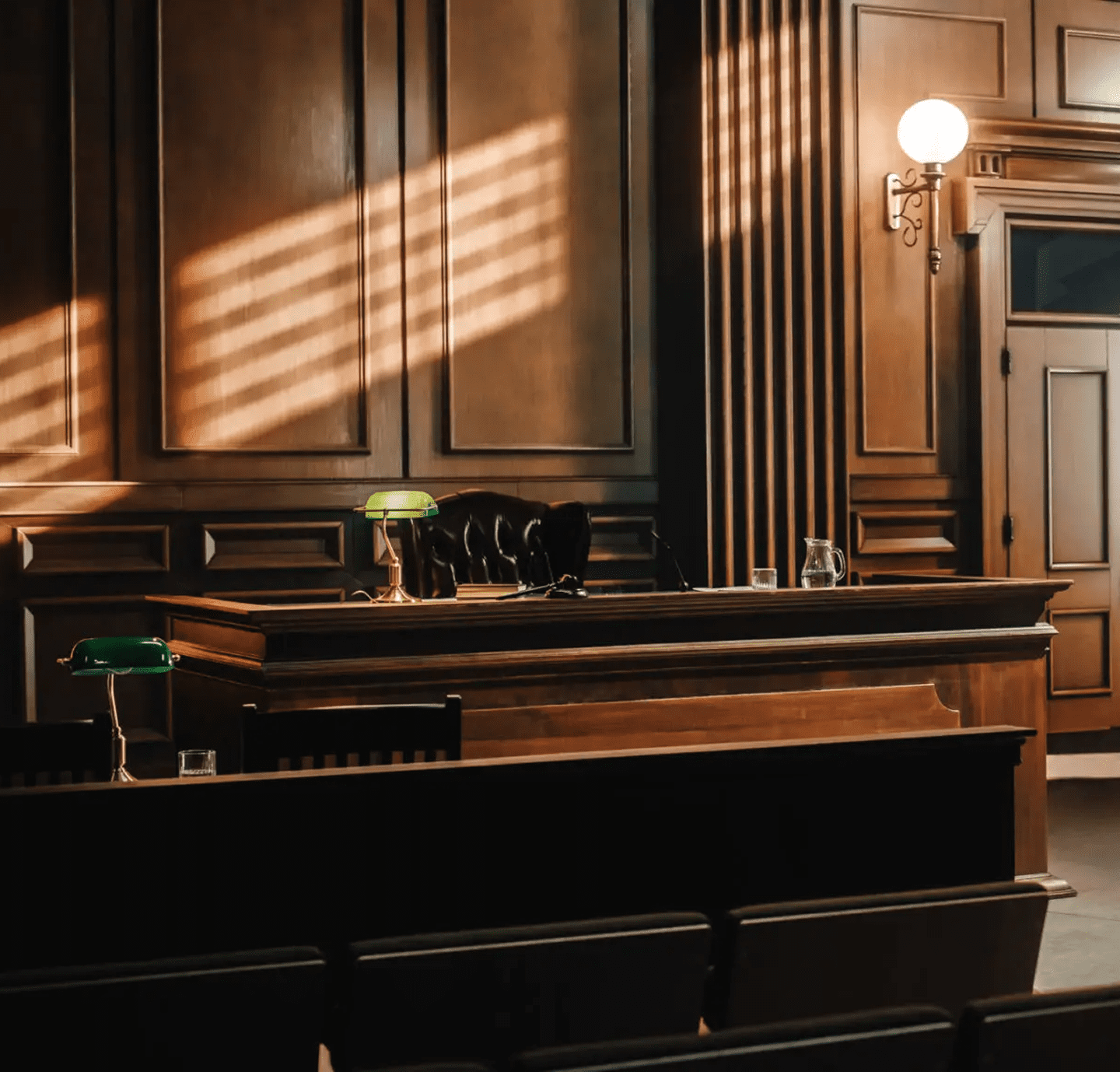 Sunlit wood-paneled courtroom with judge's bench